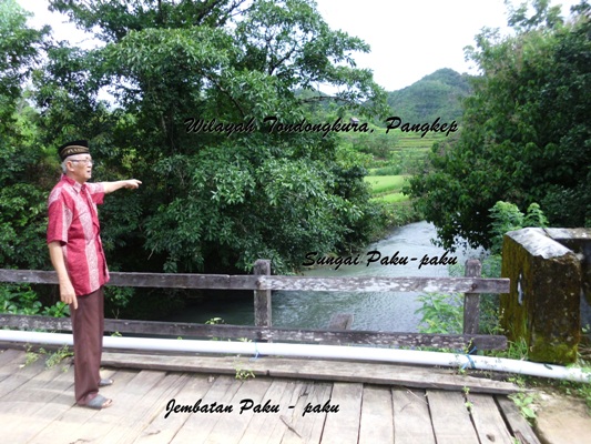 H. Puang Tompo menunjukka wilayah Tondongkura di sebelah selatan Jembatan Paku-paku (foto: mfaridwm)
